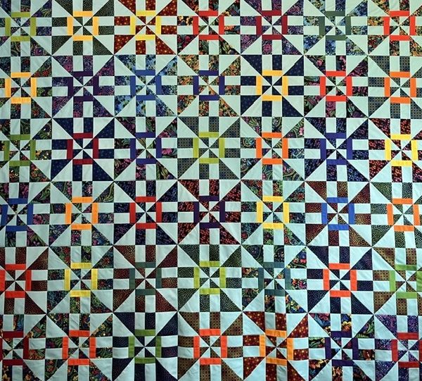 The Whirlwind Quilt Pattern is a colorful disappearing pinwheel block with a twist.